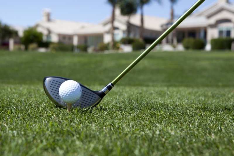 Close-up of a golf ball about to be hit in a field